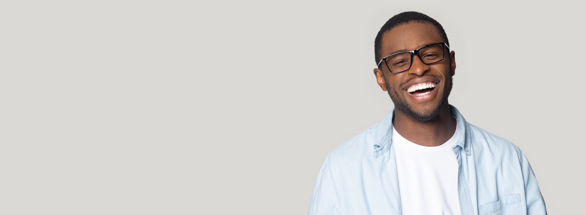 Hudson Orthodontics - Young man smiling wearing glasses